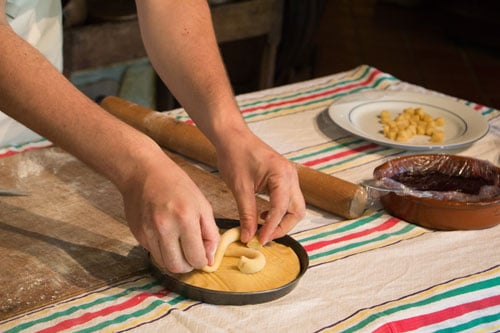 De banketbakker van het Musée du Gâteau Basque versiert de taart met het traditionele Baskische kruis.