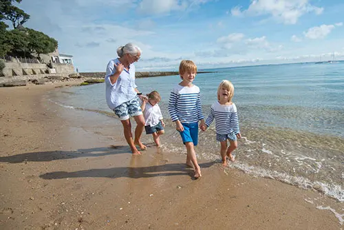 Een vrouw loopt met 3 kinderen op het strand van Île de Noirmoutier.zeau