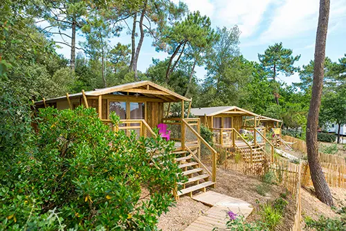 Twee houten accommodaties op een camping in Frankrijk.