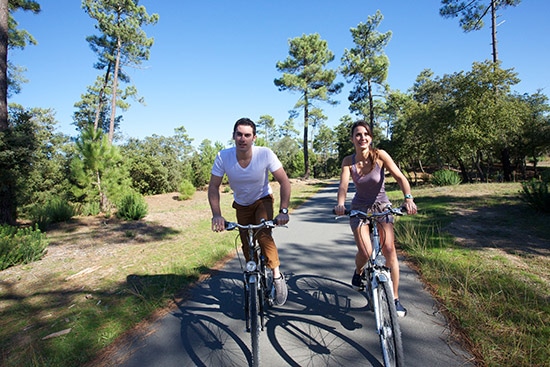 Twee fietsers rijden door het bos op het Île d’Oléron in Frankrijk.