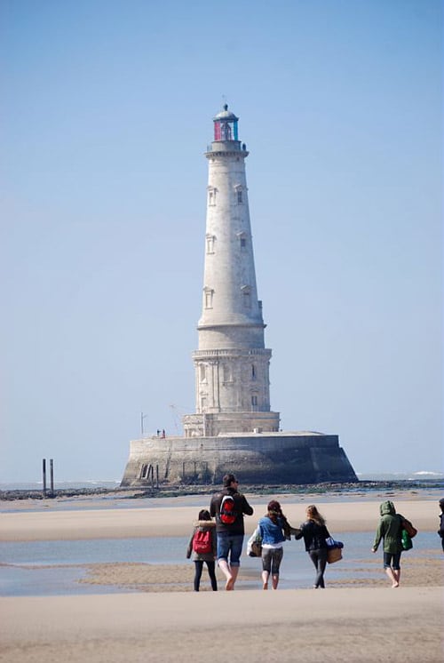 Mensen wandelen richting de vuurtoren Phare de Cordouan.