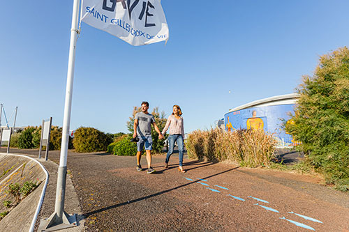 Twee mensen wandelen langs het museum Escal’Pêche in Saint-Gilles-Croix-de-Vie.