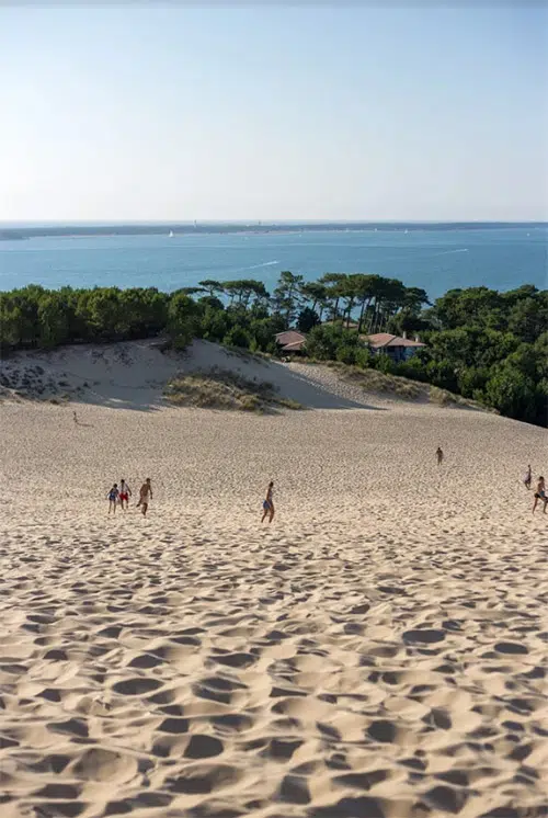 Mensen lopen over een zandduin De Dune du Pilat.