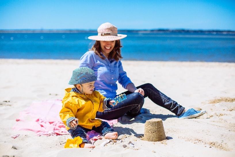 Vrouw en kind zitten op het strand Plage Pereire en maken een zandkasteel.